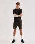 Model wearing Cuera Oncourt Airy Logo T-Shirt in Dark Brown, lifestyle action shot on the padel court