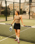 Model wearing Cuera Oncourt Cropped Tank Top in Walnut, lifestyle action shot on the padel court