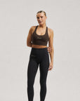 Model wearing Cuera Oncourt Soft Bra Top in Dark Brown, front studio view