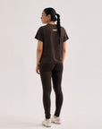Model wearing Cuera Oncourt Slit Top SS in Dark Brown, back studio view