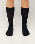 Model wearing Cuera 2-pack Bandeja Padel Socks in Black/Sand, back studio view