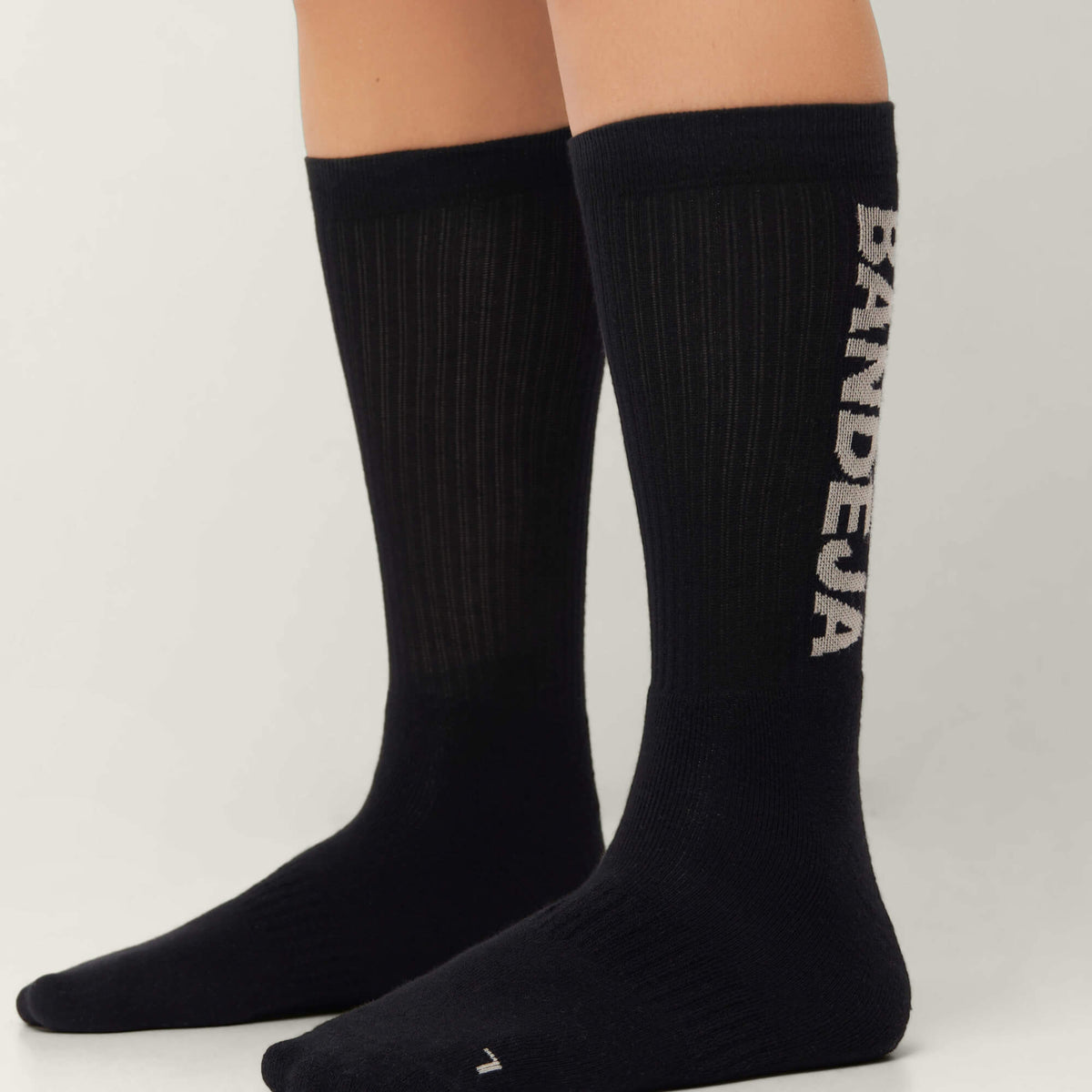 Model wearing Cuera 2-pack Bandeja Padel Socks in Black/Sand, front studio view