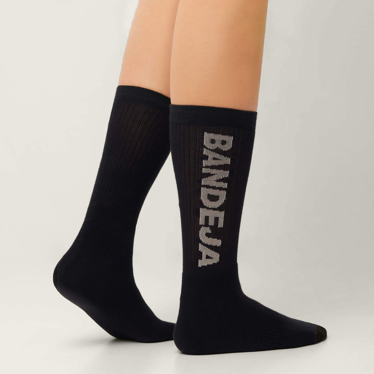 Model wearing Cuera 2-pack Bandeja Padel Socks in Black/Sand, front studio view