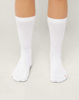 Model wearing Cuera 2-pack Bandeja Padel Socks in White/Orange, back studio view