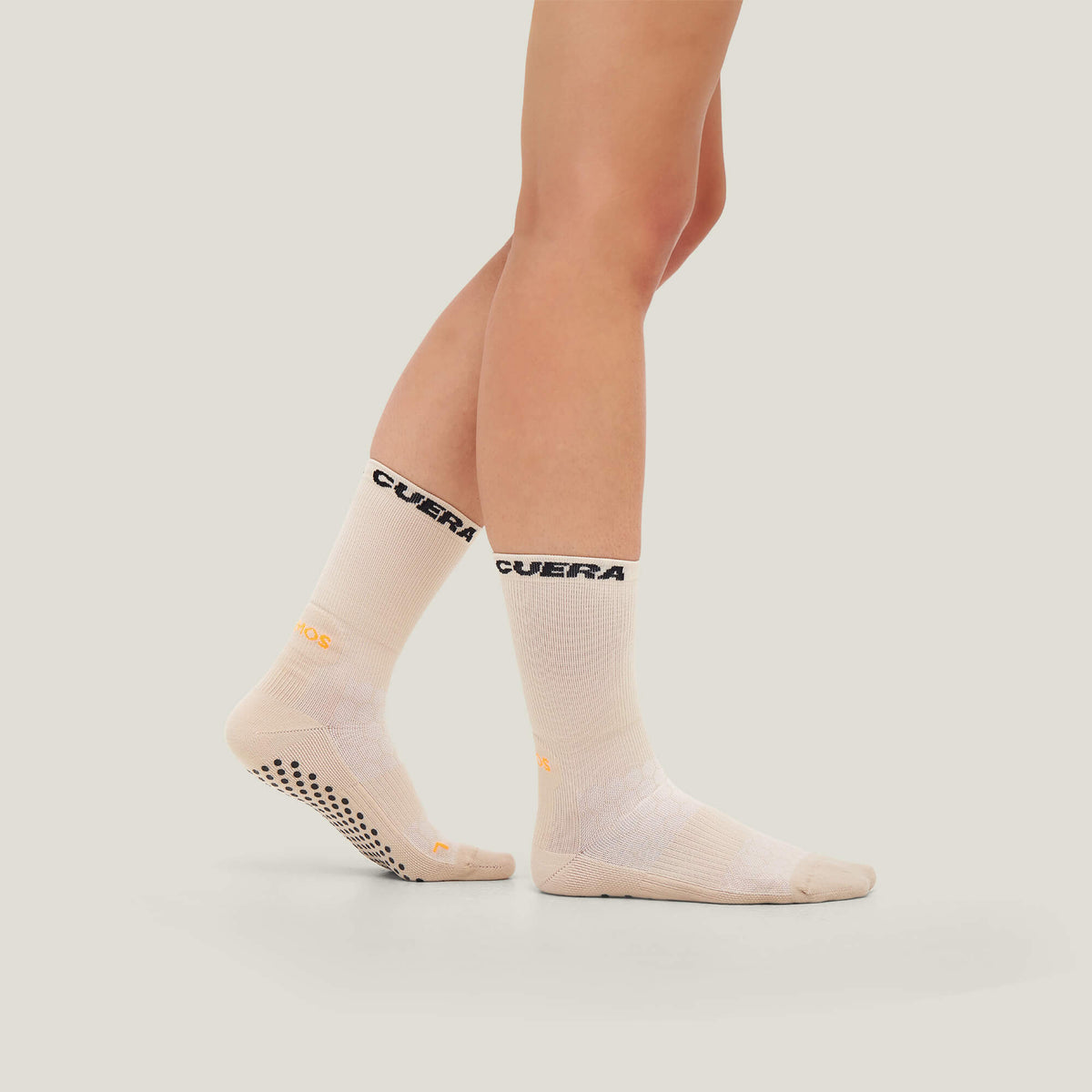 Model wearing Cuera 2-Pack Grip Socks in Sand, front studio view