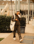 Model wearing Cuera Active Cuera Track Jacket in Army, lifestyle action shot on the padel court