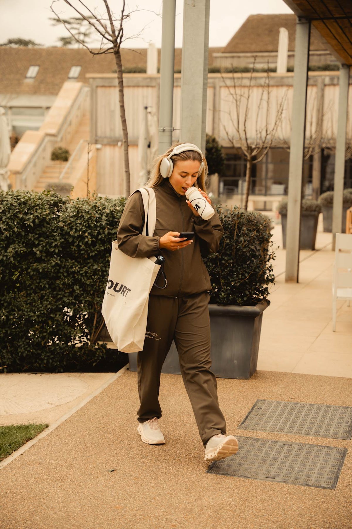 Model wearing Cuera Active Cuera Track Pants in Army, lifestyle action shot on the padel court