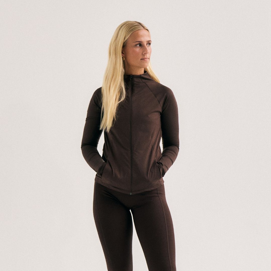 Model wearing Cuera Active Cuera Zip Cardigan in Dark Brown, front studio view