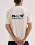 Model wearing Cuera Active Light Weight T-Shirt in Off White w. Navy/Green, back studio view