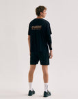 Model wearing Cuera Active Light Weight T-Shirt in Black, lifestyle action shot on the padel court