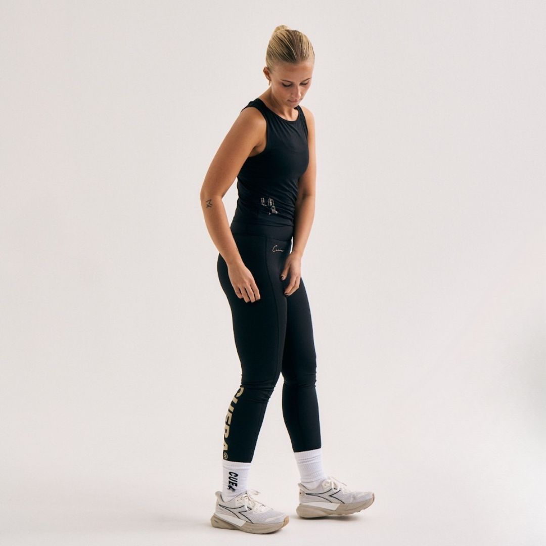 Model wearing Cuera Active Logo Tights Long in Black, front studio view