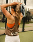 Model wearing Cuera Flame Light Weight Oversized Tank Top in Walnut, lifestyle action shot on the padel court
