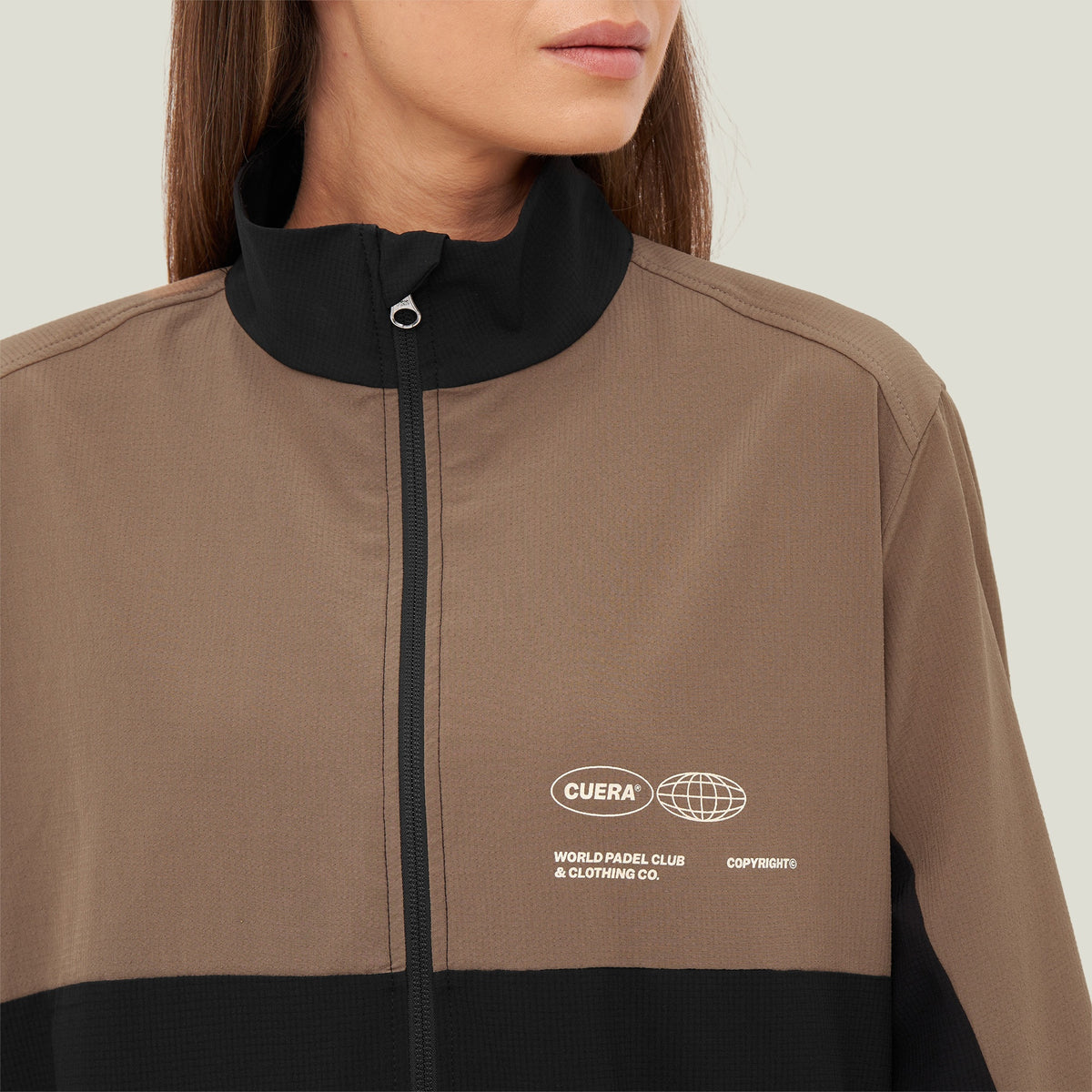 Model wearing Cuera Active Track Jacket in Black / Walnut, close-up detail on model