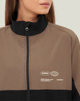 Model wearing Cuera Active Track Jacket in Black / Walnut, close-up detail on model