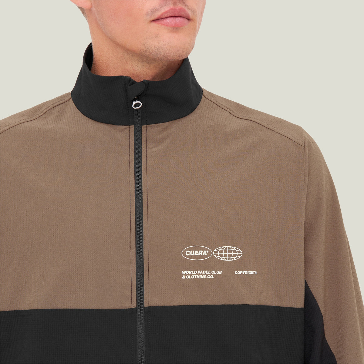 Model wearing Cuera Active Track Jacket in Black / Walnut, close-up detail on model