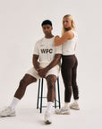 Model wearing Cuera Active WPC Light Weight T-Shirt in Off White/Walnut, lifestyle action shot on the padel court