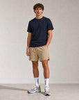 Man wearing Cuera Mens Active Globe Shorts in Sand, front studio view