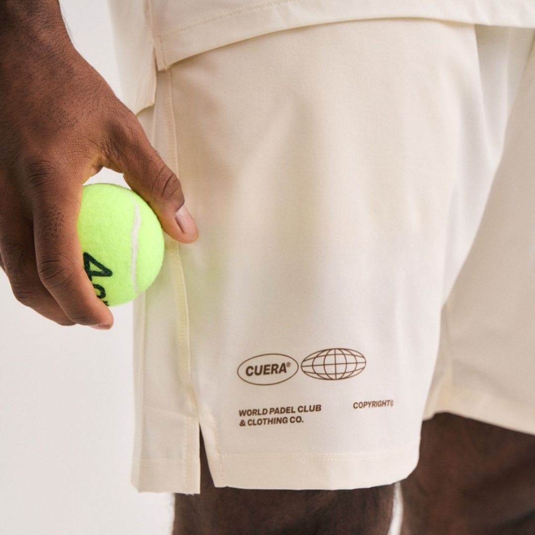 Man wearing Cuera Mens Active Globe Shorts in Off White, close-up detail on model