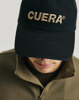 Model wearing Cuera Offcourt Cuera Cap in Black, front studio view