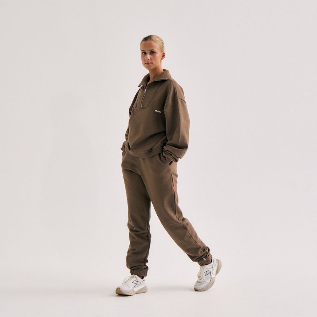 Model wearing Cuera Offcourt Cuera Sweat Pants in Walnut, front studio view