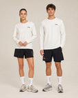 Model wearing Cuera Offcourt Logo Long Sleeve in Off White w. Black, lifestyle action shot on the padel court