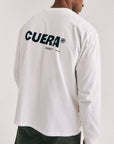 Model wearing Cuera Offcourt Logo Long Sleeve in Off White w. Black, back studio view