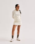 Model wearing Cuera Oncourt Cuera Skirt 2-in-1 in Off White, back studio view