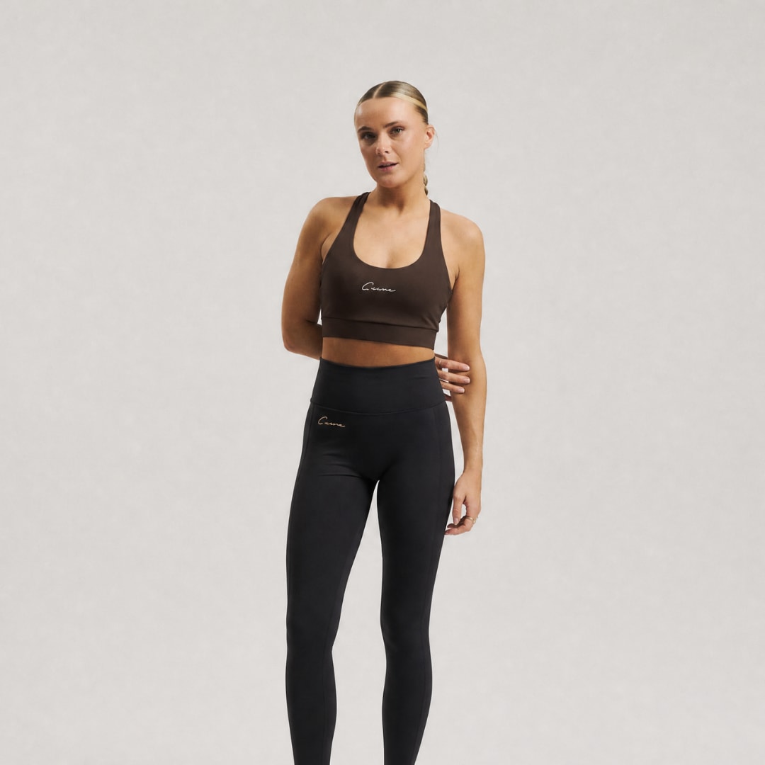 Model wearing Cuera Oncourt Soft Bra Top in Dark Brown, front studio view