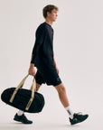 Model with Cuera Oncourt Medium Padel Bag in Black, lifestyle action shot on the padel court