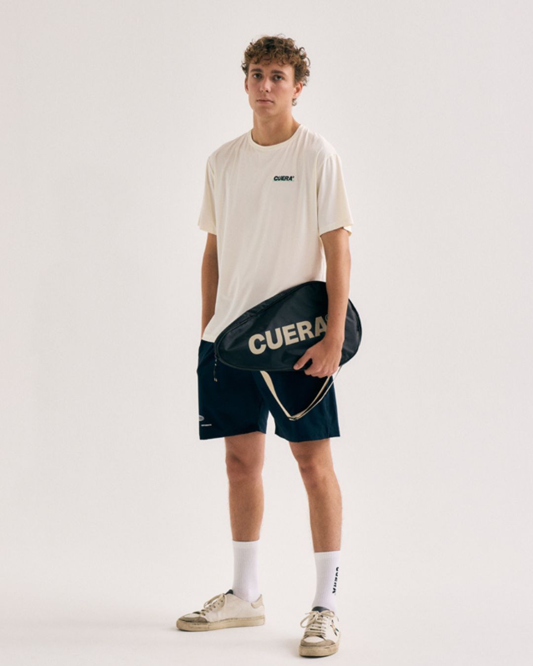 Model wearing Cuera Padel Racket Sleeve in Black, front studio view