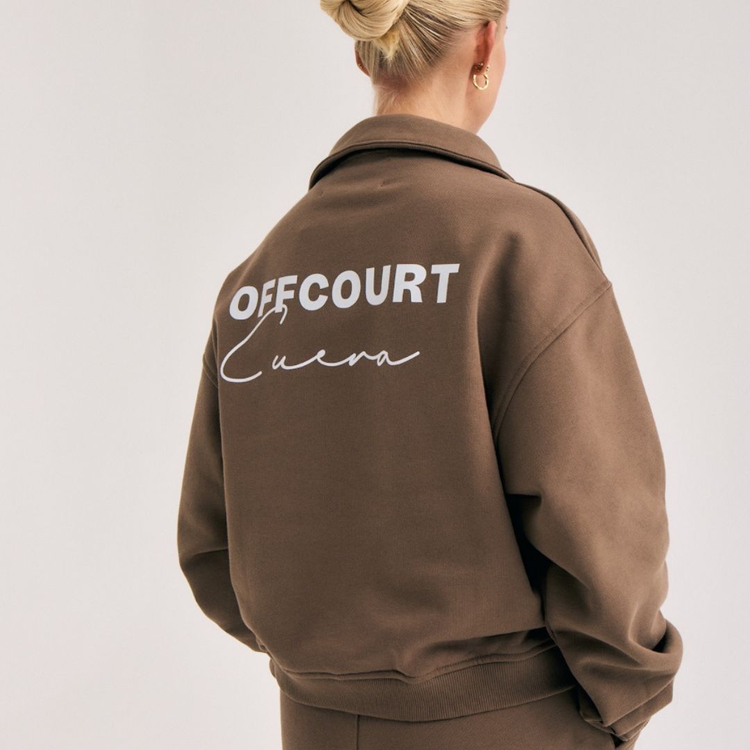 Model wearing Cuera Offcourt Cuera Half Zip Sweat in Walnut, front studio view