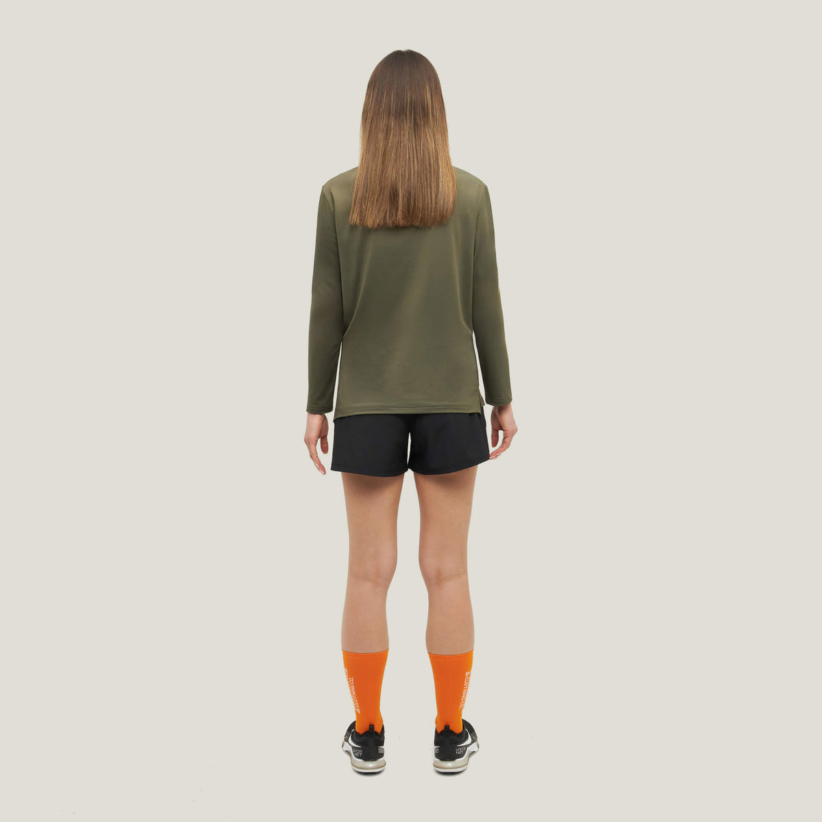 Woman wearing Cuera Women's Active Globe Shorts in Black, back studio view